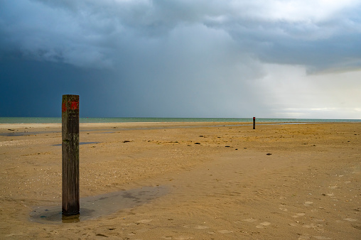 Sunrise at the beach at Texel island with a storm cloud approaching over the Wadden sea at the North point of the island facing the Wadden Sea and Vlieland.