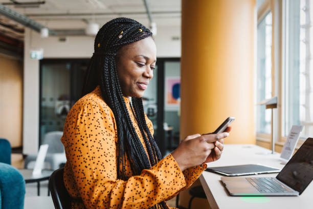 istock smiling black business woman looking at mobile in office 1725758004