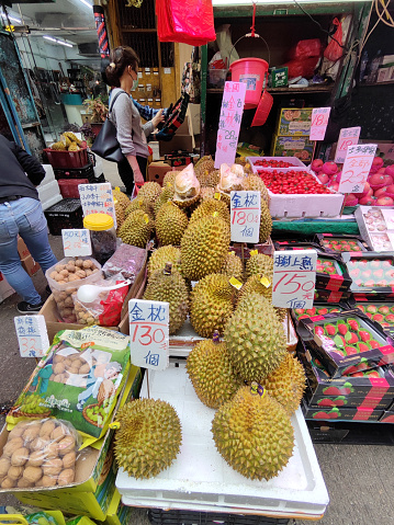 People shopping at a Durian stall on the busy fruit and vegetables market in Canton road, Mongkok district, Kowloon peninsula.