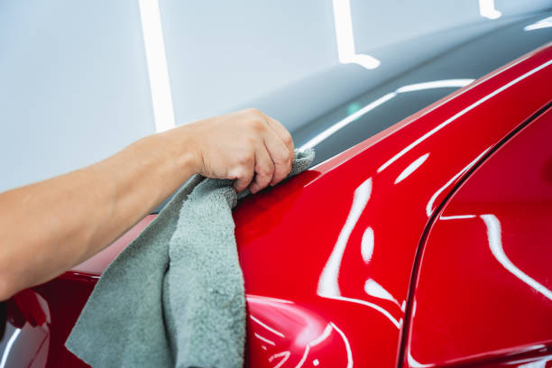 istock The process of installing protective film on the new red car. 1725780875
