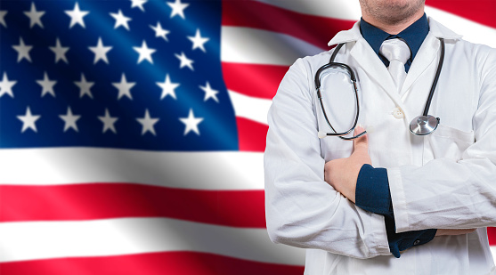 Doctor with stethoscope on USA flag. Doctor with arms crossed on USA flag, Health and care with the flag of United State