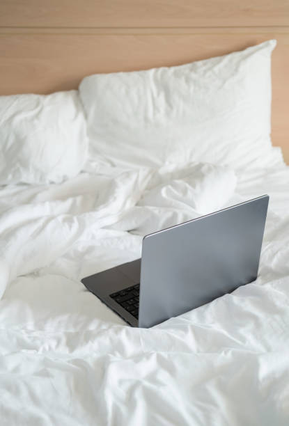 istock Laptop on white bed, work at home concept 1725798411