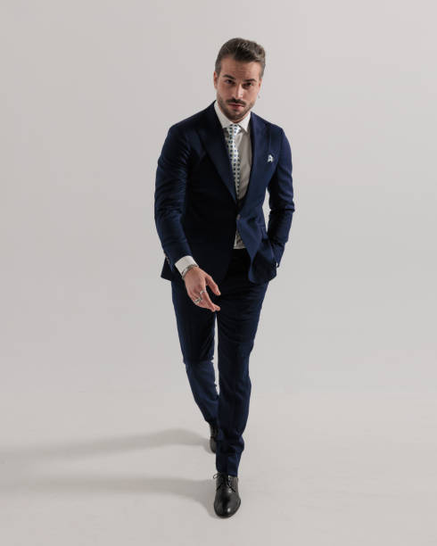 istock elegant young man walking with hand in pocket and looking forward 1725800078