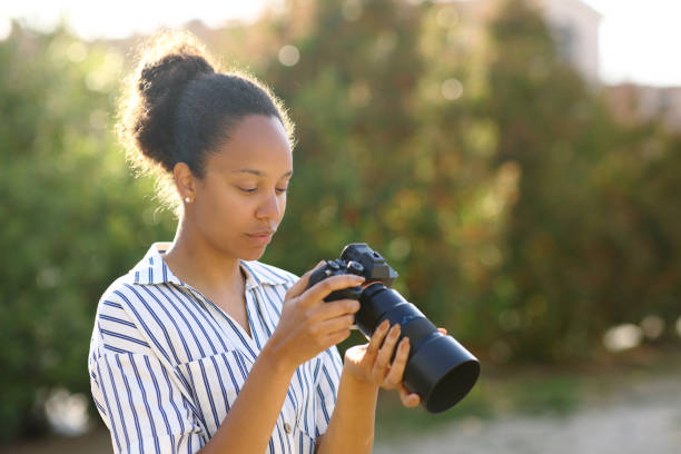 istock Black photographer checking result on camera 1725816480