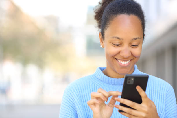 istock Happy woman using smart phone in the street 1725817565