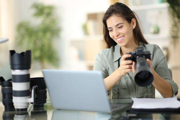 istock Happy photographer checking work on laptop at home 1725820284