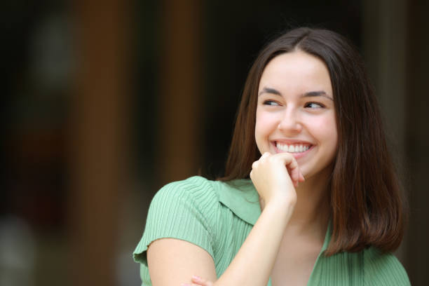 istock Happy woman thinking looking at side outdoors 1725820299