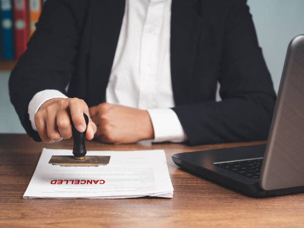 istock Businessman in a suit stamped for canceled documents while sitting at the table 1725821383
