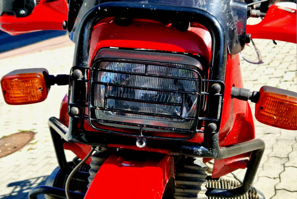 istock red motorcycle with a cross-country fender and a grille protecting the rectangular light. off-road enduro tires tread grip in mud and dusty dirt roads, brakes 1725825343