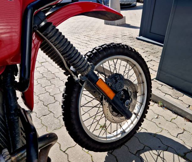 istock red motorcycle with a cross-country fender and a grille protecting the rectangular light. off-road enduro tires tread grip in mud and dusty dirt roads, brakes 1725825887