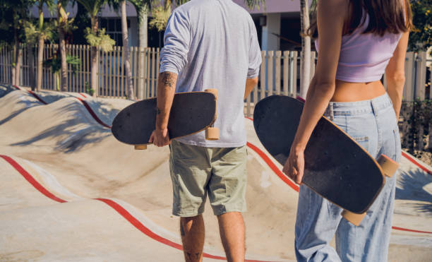 junges glückliches paar mit skateboards genießt longboarden im skatepark - 18815 stock-fotos und bilder
