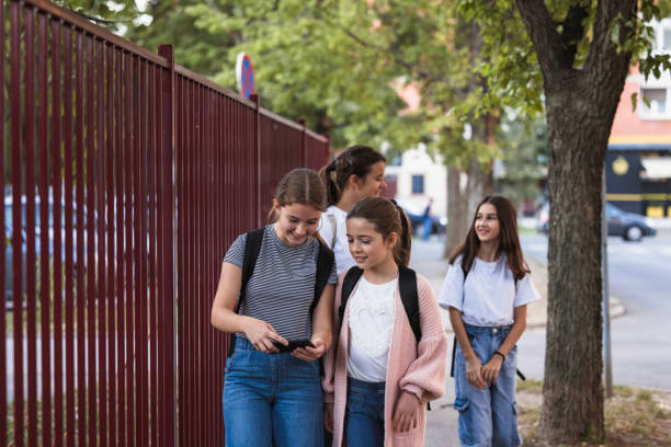 istock School girls using smart phone when walking to school 1725832027