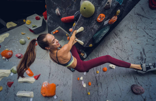 istock A strong female climber climbs an artificial wall with colorful grips and ropes. 1725835494