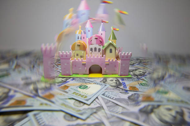 pink toy castle isolated on us 100 dollar banknotes - investment real estate construction residential structure imagens e fotografias de stock