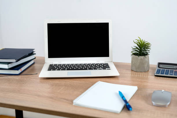 istock Planner book pen laptop on wooden office desk 1725866362