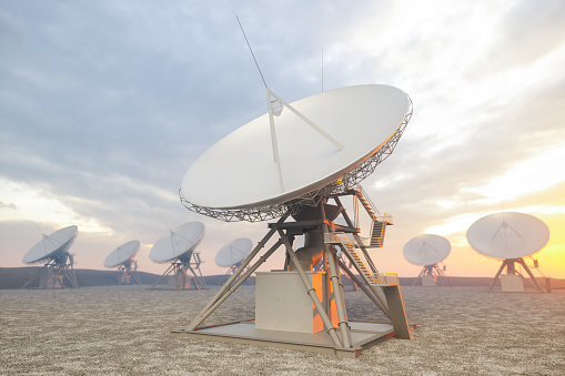 Close-up View Of Radio Antenna Dishes With Sunrise Background