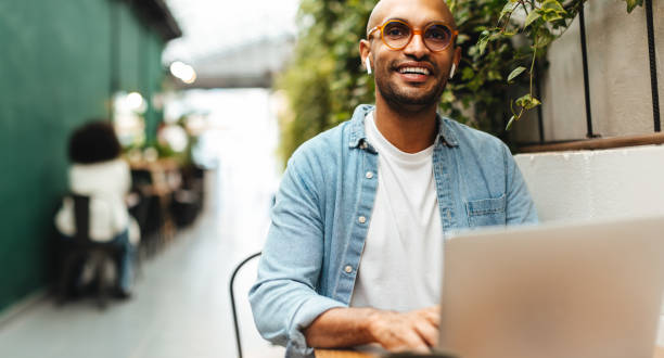 istock Happy business man sitting in a cafe, working with his laptop 1725870708