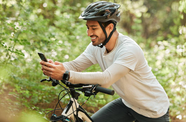 istock Man, forest and phone on bike, texting and smile for web chat notification on adventure in nature. Guy, cycling and smartphone for contact with bicycle, relax and social media app in woods on blog 1725880735