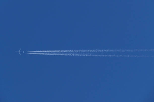 istock Airplane in the blue sky with white contrails 1725881942