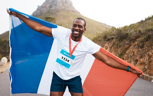Runner man, flag and winner with smile, pride and celebration for marathon, fitness and sports for France. Black guy, athlete and fabric for national sign, success or achievement at race in Cape Town