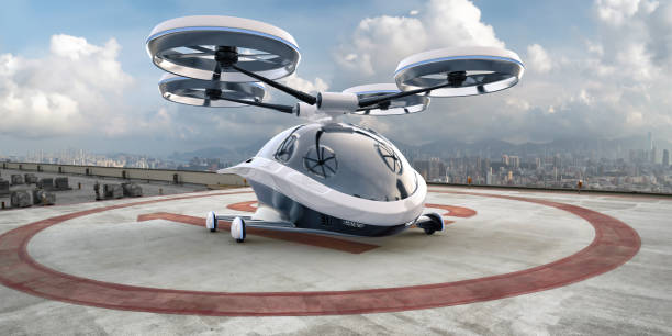 EVTOL Electric Vertical Take Off and Landing Aircraft Parked On Rooftop A generic white and grey eVTOL vehicle with blue highlights parked on a helipad on the rooftop of a high buildings in a downtown district with view of high rise city buildings in the background, under a bright sky with white clouds. helicopter modern stock pictures, royalty-free photos & images