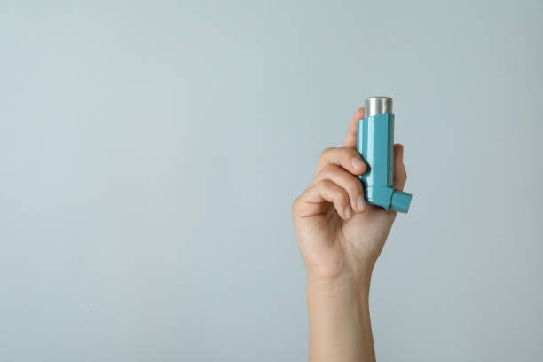 istock Female hand holds asthma inhaler on light gray background 1725910695