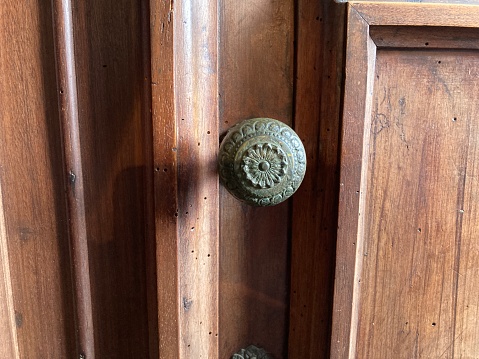 Wooden door with round old brass knob with texture