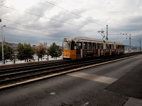 Budapest, Hungary - August 17, 2023: A tram runs along the Danube River in Budapest.