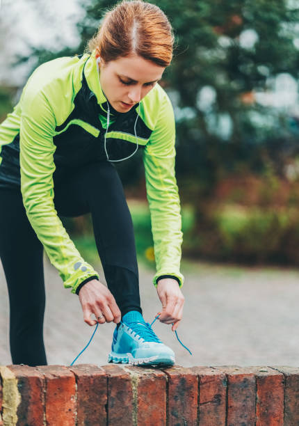 istock Woman lacing running shoes before jogging 1725953448