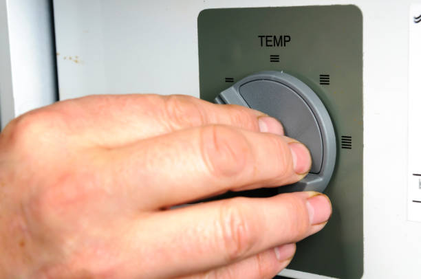 istock Man adjusts the thermostat on a domestic boiler 1725985444