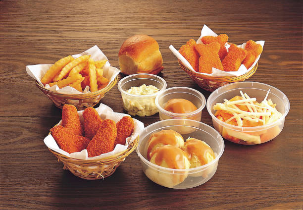 Assorted snacks with bread, chicken nuggets, french fries, mashed potatoes, coleslaw salad and fruit salad