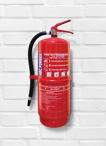 Fire extinguisher on white brick wall