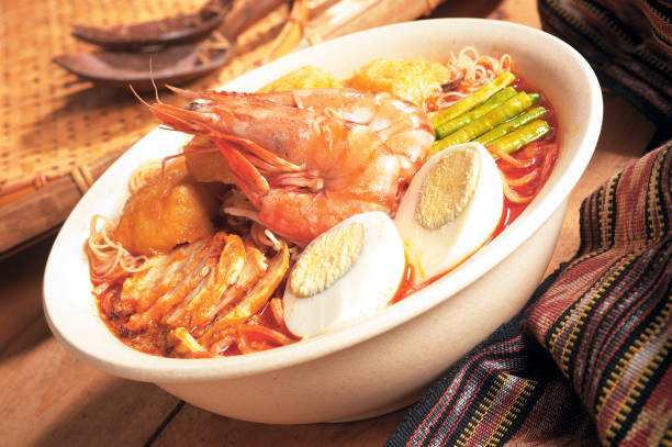 Asian style curry laksa with shrimps, boiled egg, tofu puff, roasted pork belly and vegetables