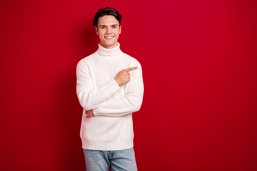 Photo of smiling brunet hair christmas guy wear white sweater recommend join new vacancy big successful company isolated on red color background.