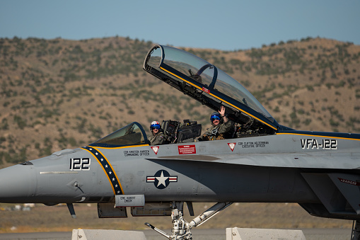 The pilots of an FA18 Super Hornet with the NU Navy Tac Demo team wave to the crowd at the Reno Stead airport during the Reno Air Races