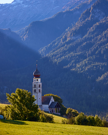 St. Valentin Church, Castelrotto Kastelruth with Mount Schlern in background in Dolomites, South Tyrol, Dolomite Alps, Italy. Cow’s are standing on the field in front of the church.