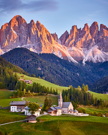Beautiful view of idyllic mountain scenery in the Dolomites with famous St. Magdalena mountain village in beautiful golden evening light at sunset in fall, Val di Funes, South Tyrol, northern Italy