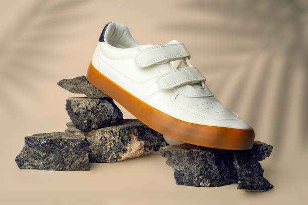 istock New sneaker shoe on stones on beige studio background 1726049031