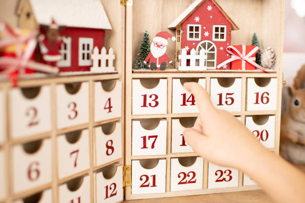 The advent calendar with Santa Claus Hand of child opens wooden advent calendar advent calendar stock pictures, royalty-free photos & images