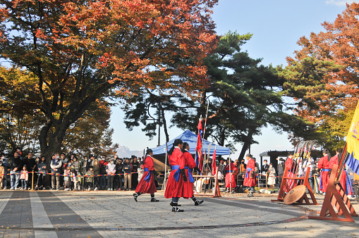 Seoul, South Korea - October 23, 2022: Traditional Korean Kingdom Soldier Warriors walks to guard among group of tourists in Namsan Mountain
