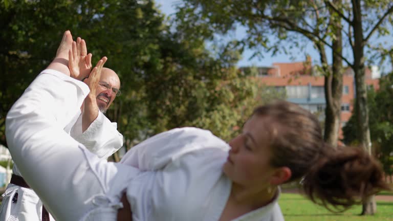 Father and daughter practicing karate/taekwondo at public park