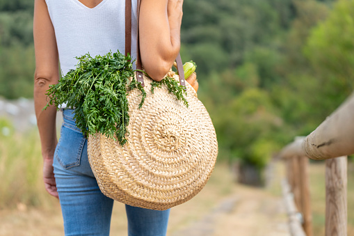 Close-up of wicker basket carried by young woman while strolling