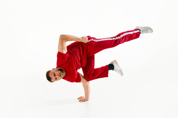 istock Stylishly dressed young man, professional dancer performing freestyle, breakdance elements, freezes against white studio background. 1726078433