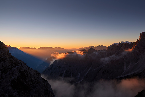 Mountain peaks during sunrise in the clouds on a beautiful morning in the Dolomites, Italy