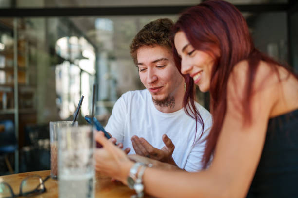 istock Young people using mobile phone at the sidewalk cafe 1726097767