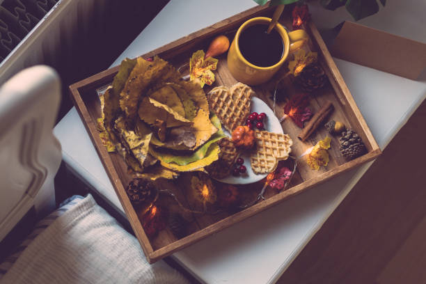 Wooden tray with breakfast and a garland on the bedside table.