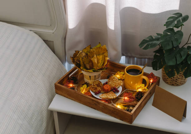 istock Wooden tray with breakfast and a garland on the bedside table. 1726101839