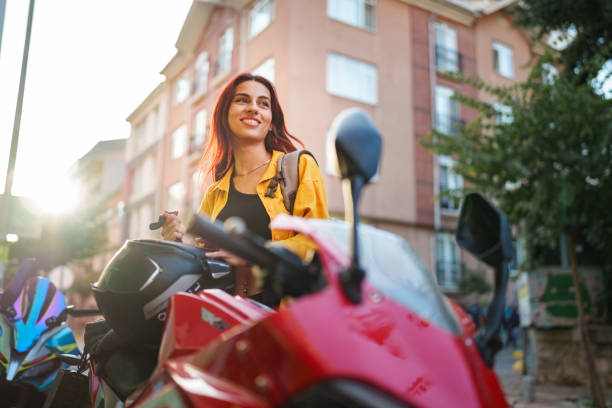 istock Young woman using mobile phone next to her motorbike. 1726103143