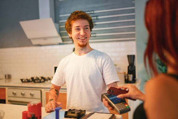 istock Young woman making a mobile payment at the cafe. 1726107587