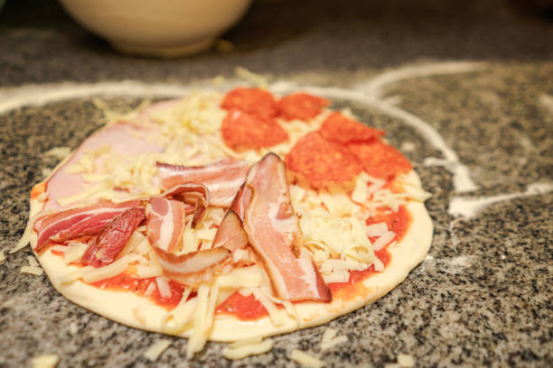 Close up shot of a delicious little homemade pizza on a parchment paper before going in the oven.